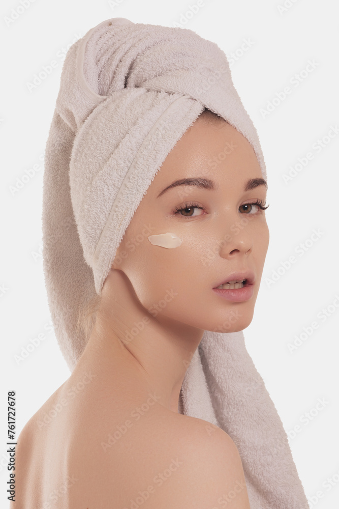 Beautiful young woman applying cream in bathroom, pretty lady wrap towel on head put facial moisturizer lifting hydrating moisturizing creme, skin care treatment concept Beautiful young woman applying cream in bathroom, pretty lady wrap towel on head put facial moisturizer lifting hydrating moisturizing creme, skin care treatment concept