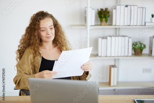 businesswoman holding and reading document paper in the office