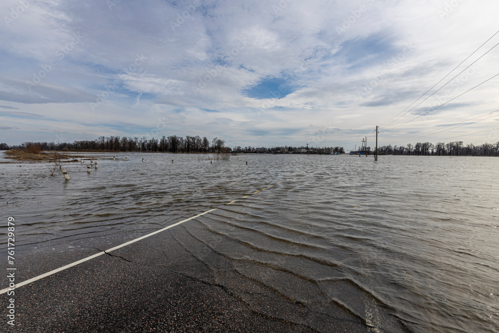 flooded road, early spring flood, river overflowing its banks, environmental pollution, ecology