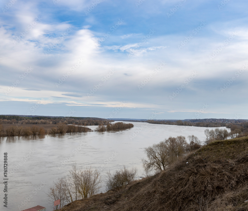 early spring flood, high water in the countryside, river overflowing its banks, trees in the water, flooded banks, environmental pollution, ecology