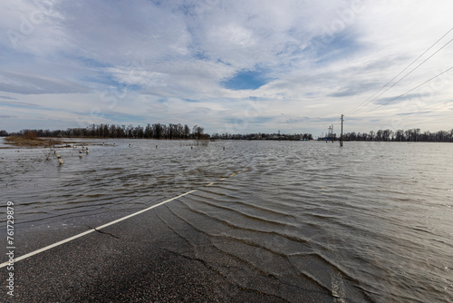 flooded road  early spring flood  river overflowing its banks  environmental pollution  ecology