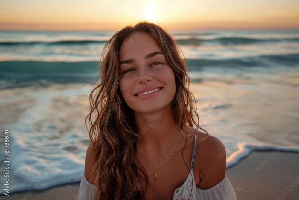 Young woman smiling at the beach during a beautiful sunset