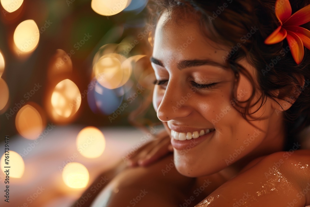 Close-up of a joyful woman relaxing at a spa with ambient lights and a flower in her hair Close-up of a joyful woman relaxing at a spa with ambient lights and a flower in her hair