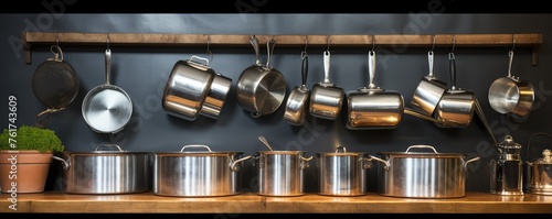 shiny stainless steel pots and pans in a professional restaurant kitchen setting © Michal