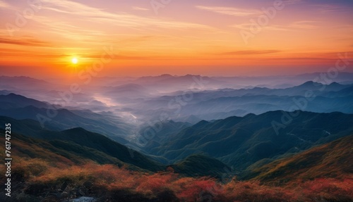  the sun is setting over the mountains in the foggy valley of a valley with trees in the foreground. © Jevjenijs