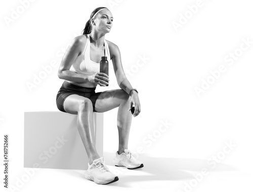 Black and white sports background. Fit woman relaxes and drinking water on seaside promenade after Workout training.