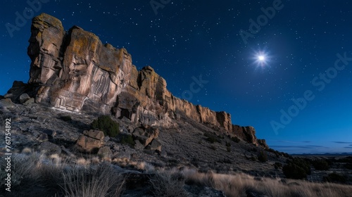 The moon illuminating a rocky mountain landscape.