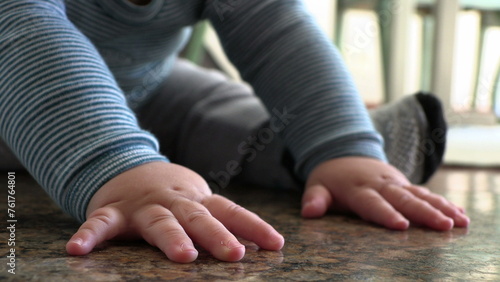 Cute baby boy hands closeup on floor