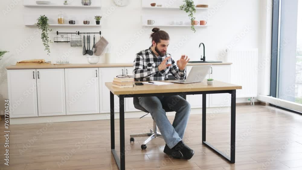 Positive man with loving feelings using internet app showing heart shape to his loving partner. Happy Caucasian male in button-down shirt talking to family over video call while staying at home. Positive man with loving feelings using internet app showing heart shape to his loving partner. Happy Caucasian male in button-down shirt talking to family over video call while staying at home.