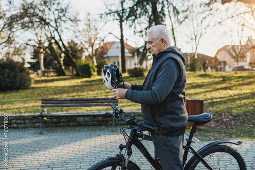 Older Man Wearing Helmet and Holding Bike