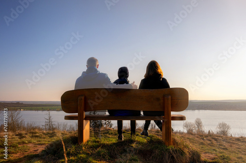 Verlust eines Familienmitglieds dargestellt mit leicht transparentem Mann mit Familie auf einer Parkbank