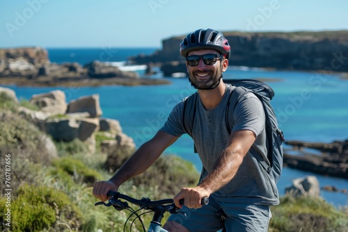 Cheerful man cycles along the coast, enjoying the sunny seaside landscape © Татьяна Евдокимова