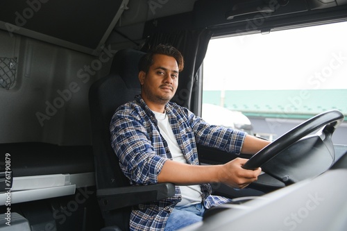 A young Indian male truck driver sits behind the wheel © Serhii
