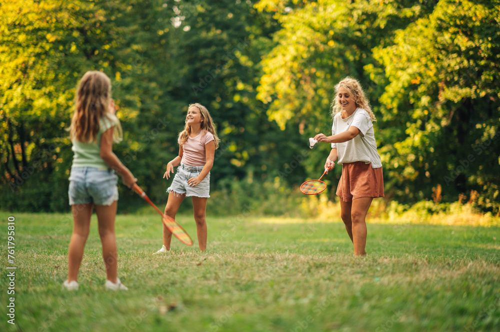 A mother is playing badminton with her daughter in nature. A mother is playing badminton with her daughter in nature.