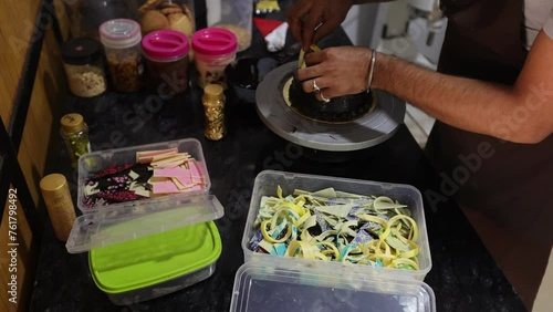 Making cakes to order. Unrecognizable Male cook decorates candied chocolate cake in his kitchen. 