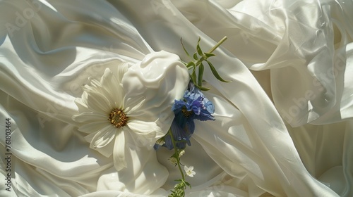 a close up of a white cloth with blue flowers on it and a blue flower in the middle of the fabric. photo