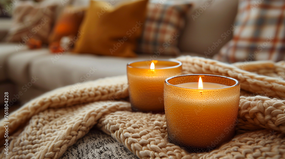 Burning candles on beige knitted plaid, closeup Burning candles on beige knitted plaid, closeup