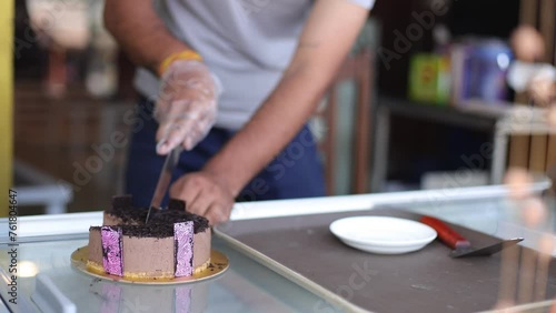 Chef cuts cake into pieces in cafe, restaurant, bar. Making sweet desserts. Bakery. Own production. Candy bar. Cutting cake . Close-up. Restaurant business. Culinary masterpieces.