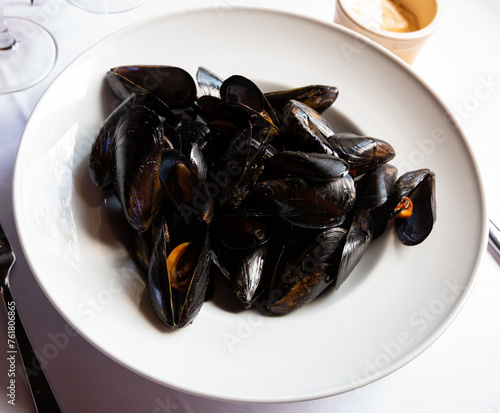 Image of delicious grilled mussels on plate, served with ali-oli sauce photo