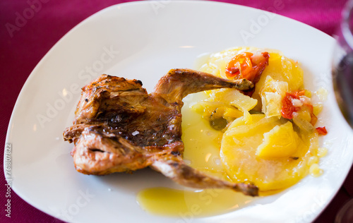 Poultry dish - grilled quail meat served with potatoes, vegetables and sauce on plate
