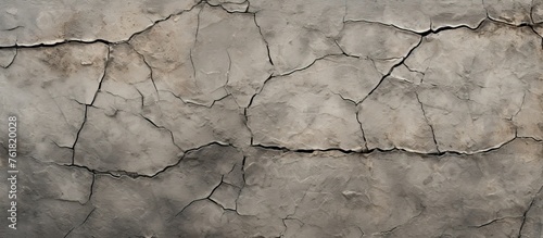 A close up of a cracked grey concrete wall with wood twigs and freezing liquid forming composite material on the surface, contrasting the natural landscape background