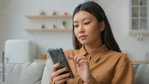 Obraz na plátně Korean chinese multiracial woman use smartphone application surfing internet soc