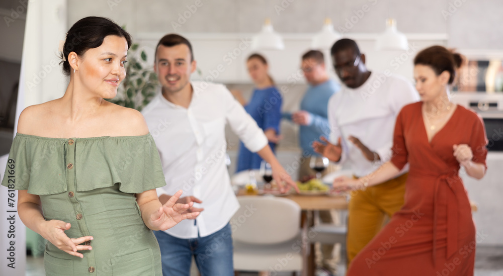 Dance moves of men and woman of different nationalities at a fun holiday party at home