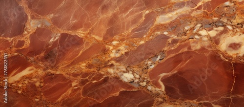 A close up of a red marble texture resembling a dish made from natural material. The pattern resembles the landscape of soil and wood in brown and amber tones with hints of peach