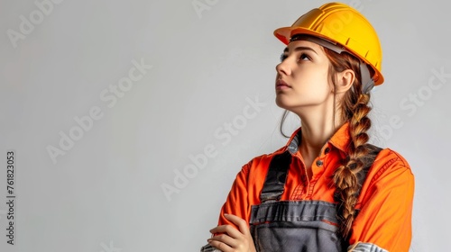 Female wearing coverall and hard hat on white background with copy space © Kate Mayer