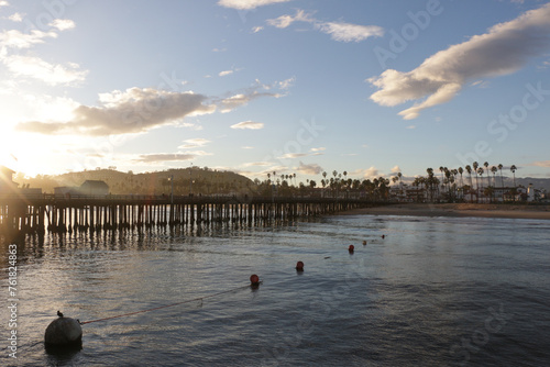 Looking over Stearns Wharf in Santa Barbara, California at sunset with palm trees.