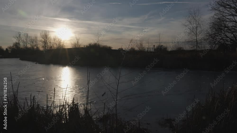 Serene Sunset Over a Frozen Lake with Scenic Silhouettes
