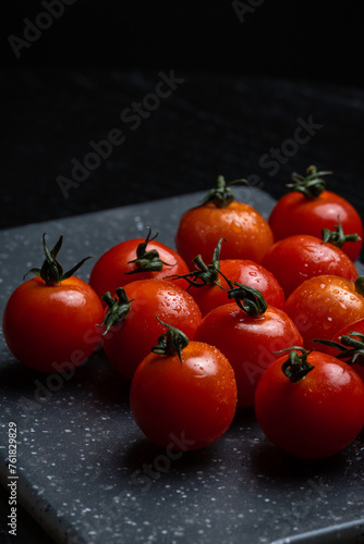 Fresh delicious ripe red cherry tomatoes on a cutting board.