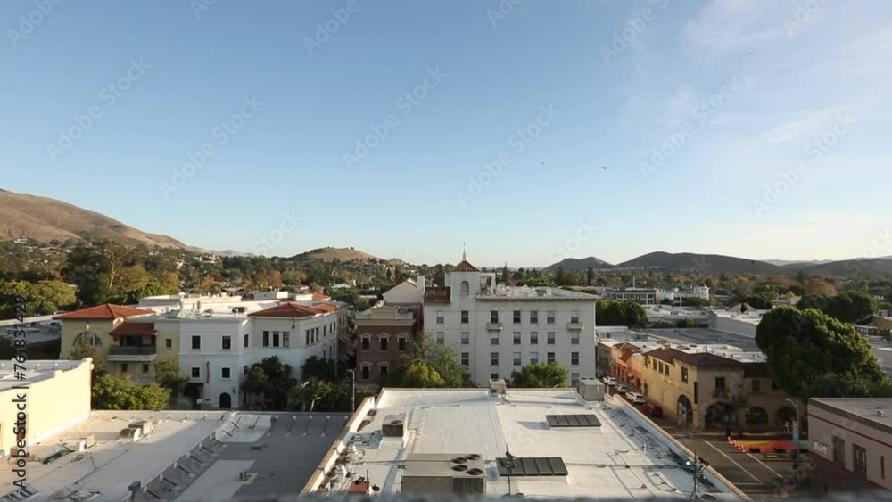 San Luis Obispo, California, USA - December 3, 2021: Aerial view of afternoon light shining on the historic buildings of the downtown core. San Luis Obispo, California, USA - December 3, 2021: Aerial view of afternoon light shining on the historic buildings of the downtown core.