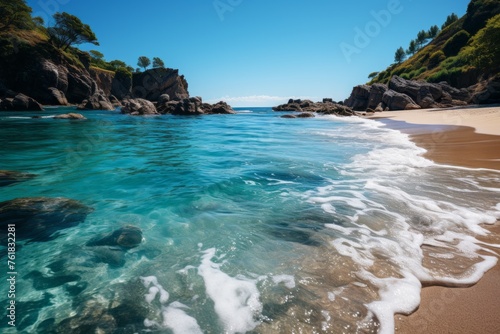 a beach with waves crashing against the rocks on a sunny day
