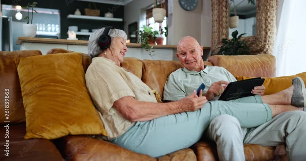 Technology, music and internet with senior couple on sofa in living room of home to relax together. Tablet, phone or headphones for streaming with happy elderly man and woman in retirement apartment Technology, music and internet with senior couple on sofa in living room of home to relax together. Tablet, phone or headphones for streaming with happy elderly man and woman in retirement apartment