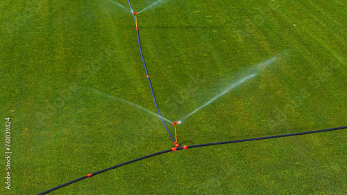AERIAL: Sprinklers spraying fresh water to help grow sod a large industrial farm photo