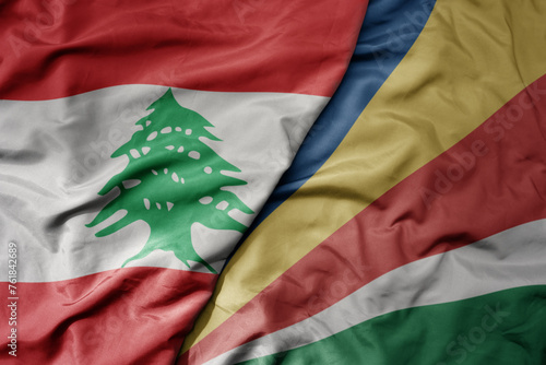 big waving national colorful flag of seychelles and national flag of lebanon. photo