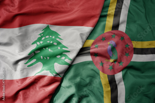 big waving national colorful flag of dominica and national flag of lebanon. photo