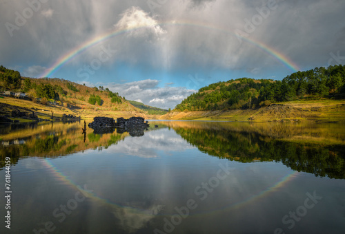 A complete rainbow and its reflection in the river