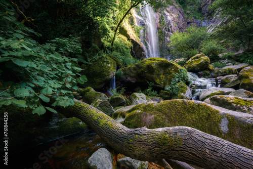 A fallen trunk in the course of the stream that forms the Toxa waterfall photo