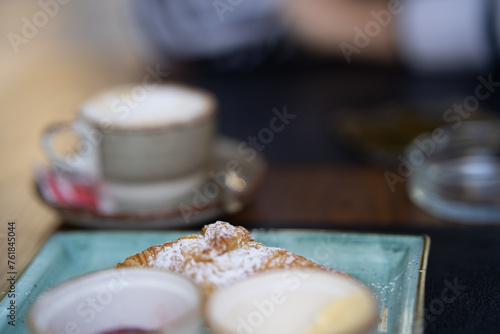 Close-up of a pastry with coffee cup in soft focus