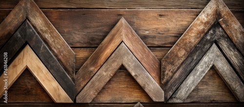 A pile of wooden frames arranged in a triangular and rectangular shapes on a hardwood surface, resembling brickwork. The wood pieces may be used for flooring, facade, or roof construction
