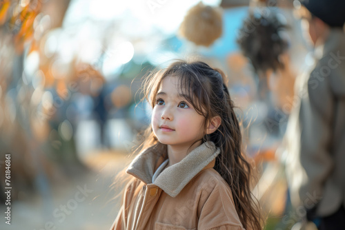Portrait of a beautiful asian little girl in the autumn park © Evgeny