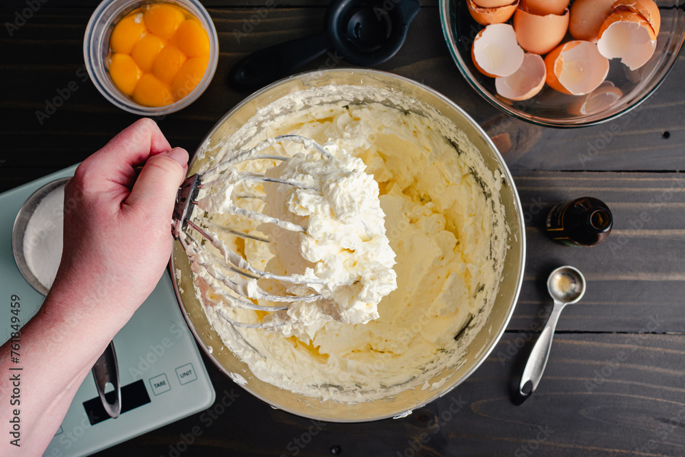 Hand Holding a Stand Mixer Whisk Attachment Covered in Buttercream