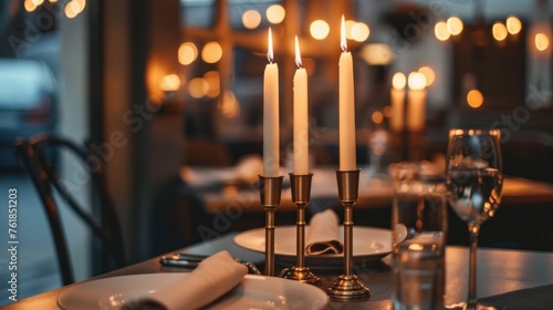 Tall candle-holders with thin candles in them stand on dinner table