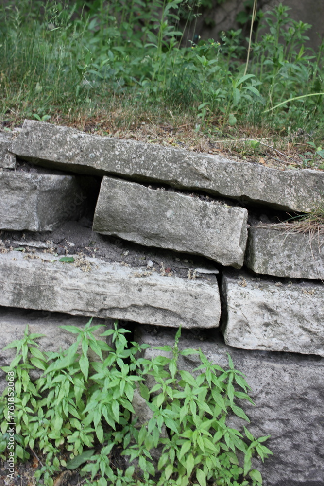 Old tombstones piled into a wall.