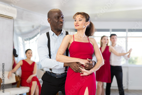 Adult man and adult woman dance ballroom dance waltz in studio