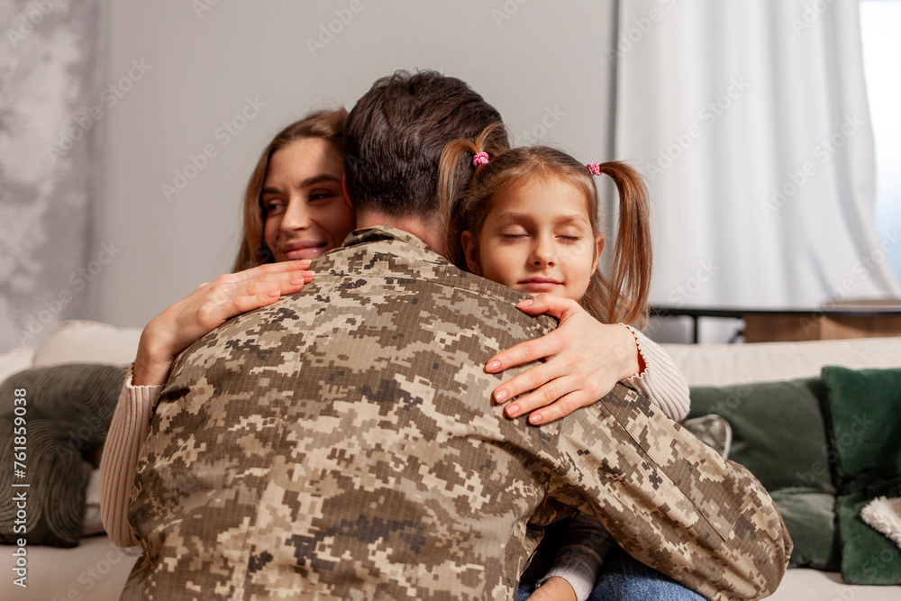 military man of the Ukrainian army in camouflage uniform returned home and hugs his family, soldier goes to war and says goodbye to his daughter and wife, the concept of mobilization in Ukraine military man of the Ukrainian army in camouflage uniform returned home and hugs his family, soldier goes to war and says goodbye to his daughter and wife, the concept of mobilization in Ukraine