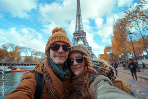 Young Couple with beanies and sunglasses taking selfie  in Front of Eiffel Tower at winter time.