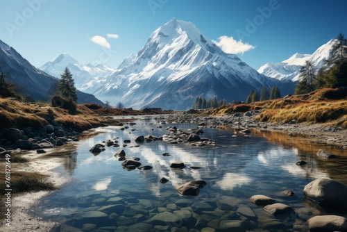 A river flows through a mountain valley with a snowy peak in the background